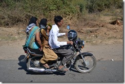 Typiskt indiskt transportsätt: Varför använda hjälm när man kan hänga den på styret?